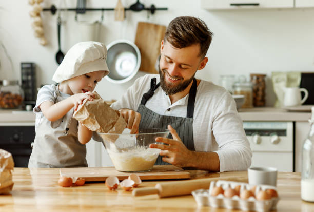 istock Happy man with kid preparing dough at home 1291937301