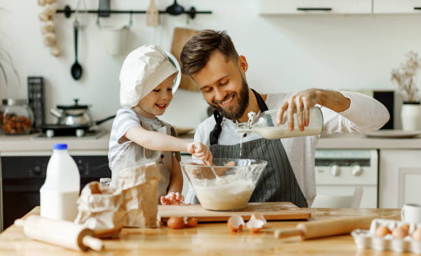 istock Happy man with kid preparing dough at home 1291937355