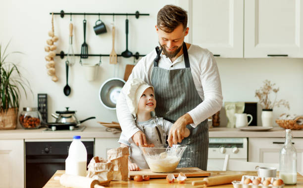istock Happy man with kid preparing dough at home 1291937408