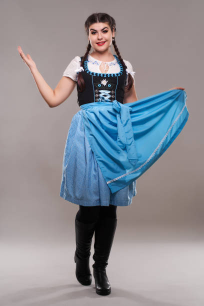 Young woman in traditional German folklore costume, isolated on gray background