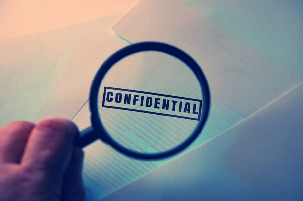 istock hand holds a magnifying glass over the inscription confidential 1291938882