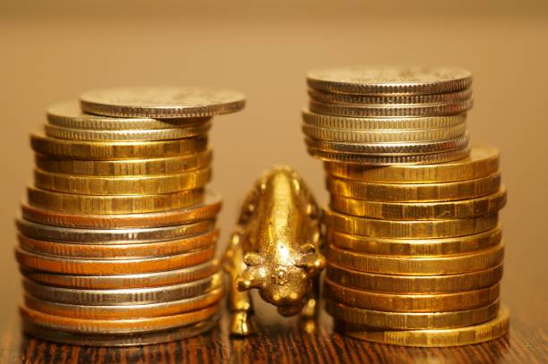 Metal bull with coins on a gold background.