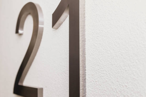 istock Number twenty one on texture light wall, symbolizing year 2021 1291941819