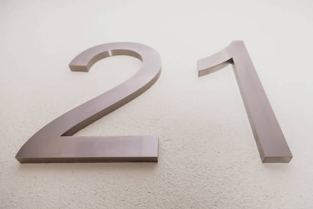 istock Number twenty one on texture light wall, symbolizing year 2021 1291941823