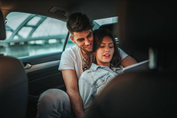 istock Young couple using tablet in the car 1291943355