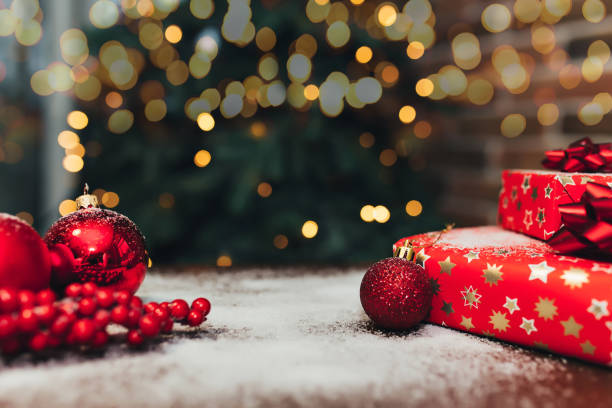 istock Red christmas decorations and gifts on the table, blurred lights 1291951586