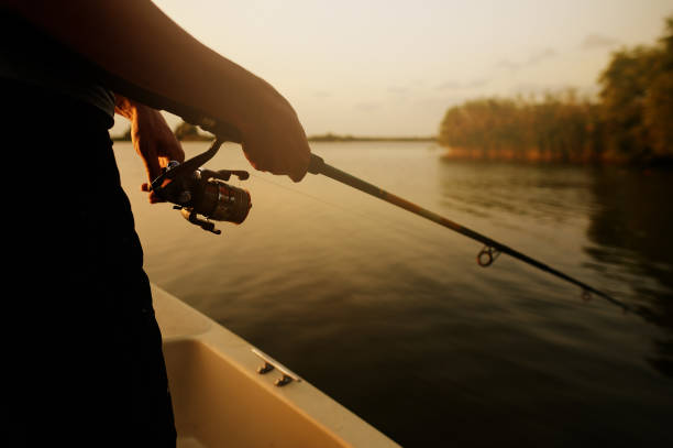 istock Fishing rod held by man at the lake 1291954495