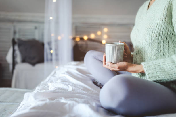 istock Young woman drinking coffee at home 1291954527