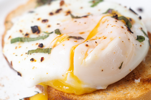 poached egg on toasts with yolk stains close-up