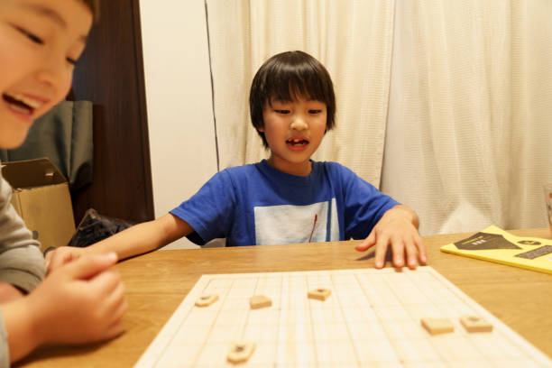 istock Children playing at home - Shogi (Japanese chess) 1291956848