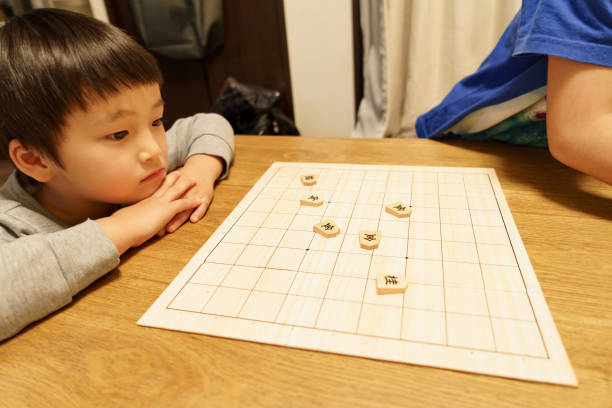 istock Children playing at home - Shogi (Japanese chess) 1291956884
