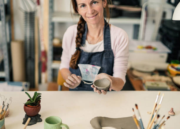 istock Woman shows hand made ceramics from clay - Creative ceramic pottery studio - Handmade handcraft 1291957418
