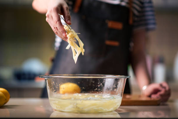 istock Woman putting thin potato slices into water 1291965434