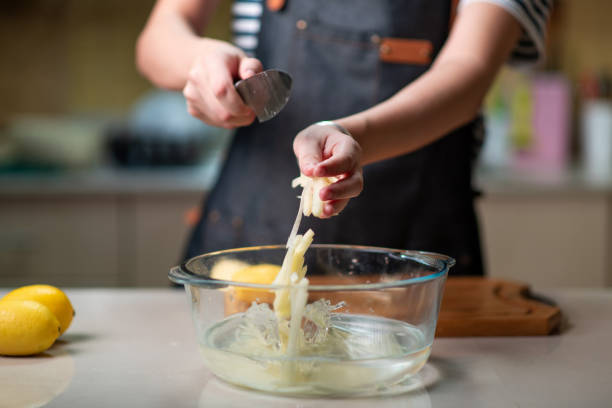 Woman putting thin potato slices into water