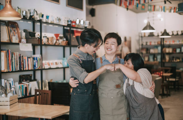 asian cafe down syndrome disability employee and owner fist bump bonding time in cafe happily employee cafeteria worker photos stock pictures, royalty-free photos & images