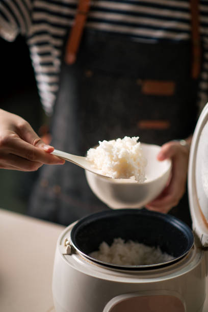 istock Woman taking out and serving fresh boiled rice from the cooker 1291965734