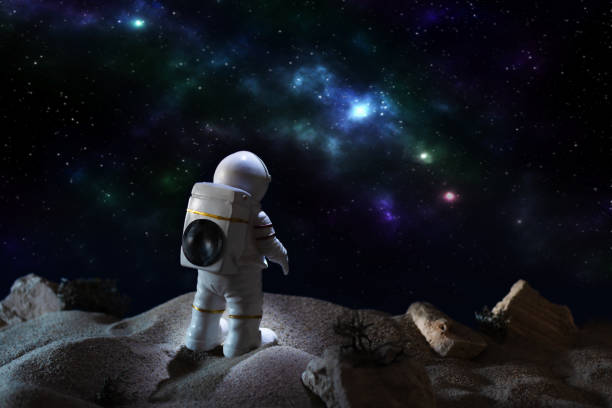 istock Astronaut in a space suit looking at milky way galaxy. 1291967211