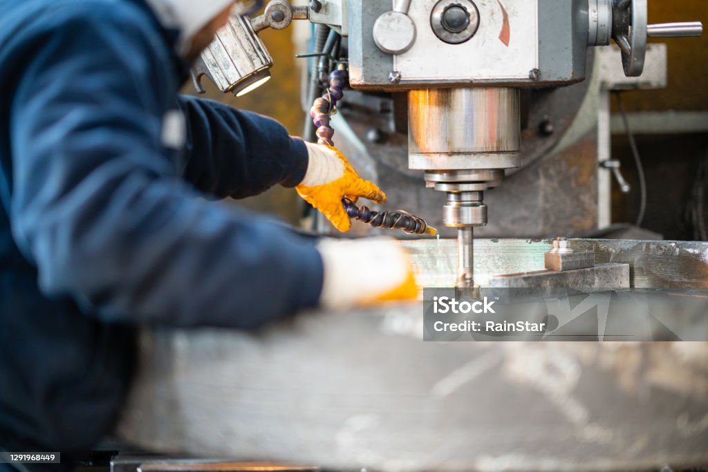 A worker in a factory working on a traditional milling machine Manufacturing Stock Photo