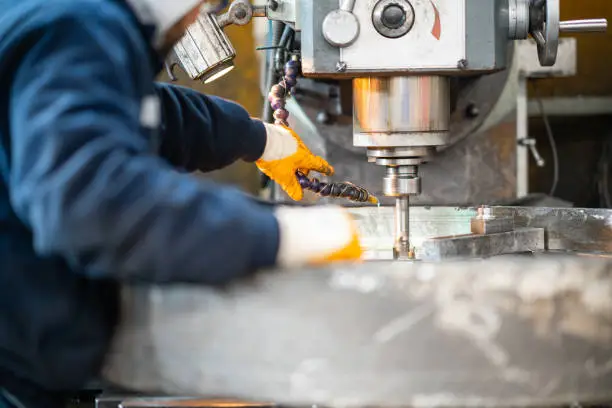 A worker in a factory working on a traditional milling machine