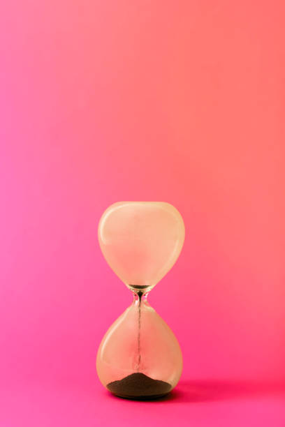 istock Hourglas on rose pink background. Concept of time 1291969710