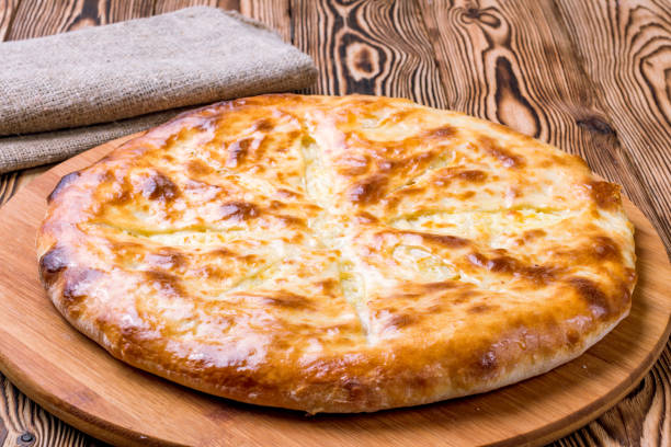 istock Ossetian pie with cheese and potatoes on wooden table 1291969900