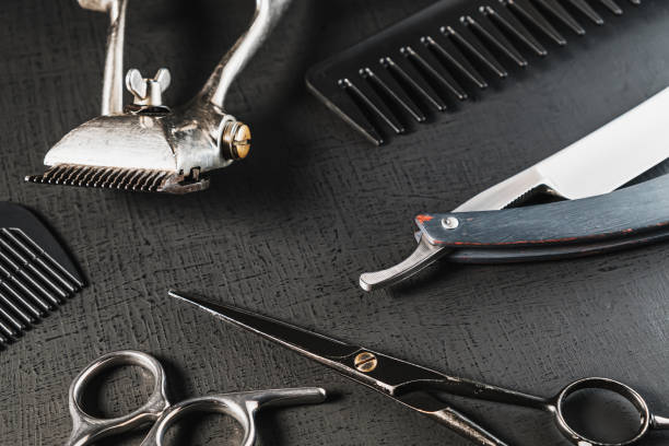 istock vintage barber tools. dangerous razor, hairdressing scissors, old manual clipper, combs, shaving brush. black monochrome 1291971081