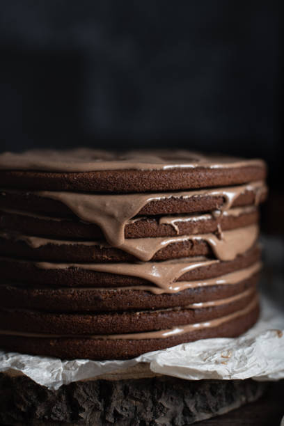 istock the process of making a large chocolate cake from thin layers. Close-up cake on a dark background. 1291973825
