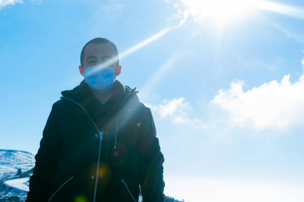 istock Lonely man in snowy mountains with protective mask 1291973845