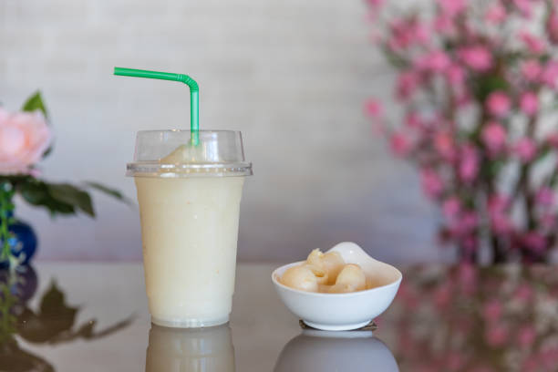 le jus froid de litchi de smoothie dans le verre en plastique enlève le verre. lychee frappe fruitée. smoothie au litchi. - 13414 photos et images de collection