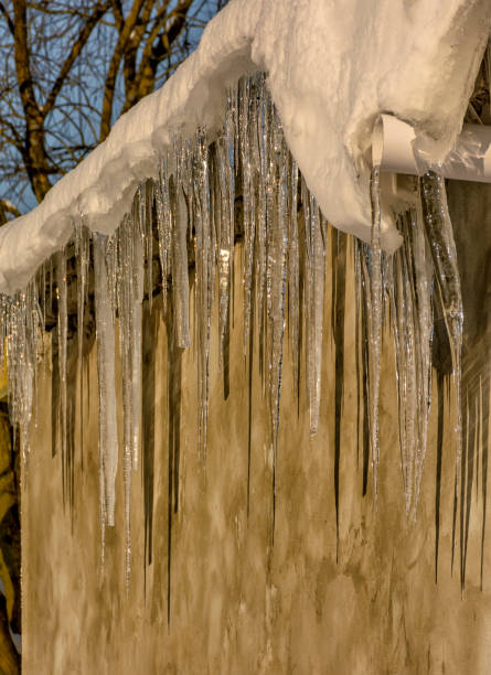 istock Large icicles formed on the roof during the thaw. 1291978905