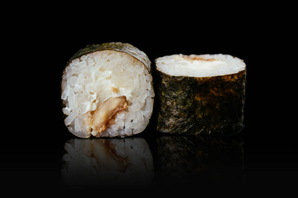 istock Japanese sushi rolls on a black background 1291979642