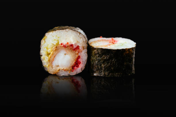 istock Japanese sushi rolls on a black background 1291979648