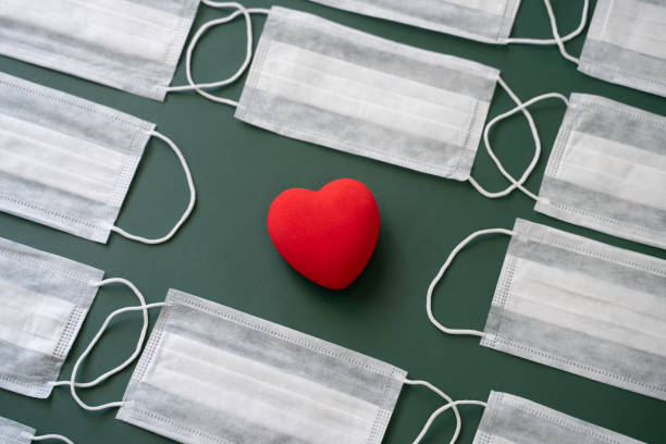 istock Pattern made of protective face masks with a red heart 1291980414