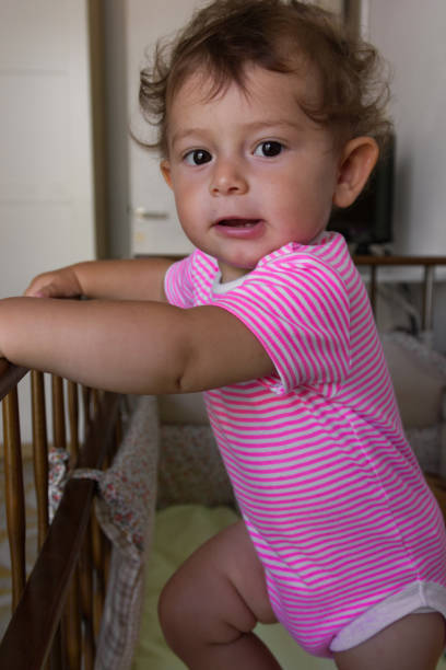 istock Playful baby standing in the crib 1291980922
