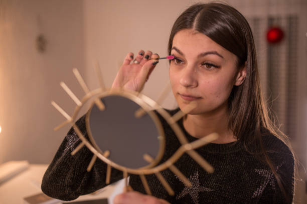 istock Young woman applying mascara at her home 1291981155