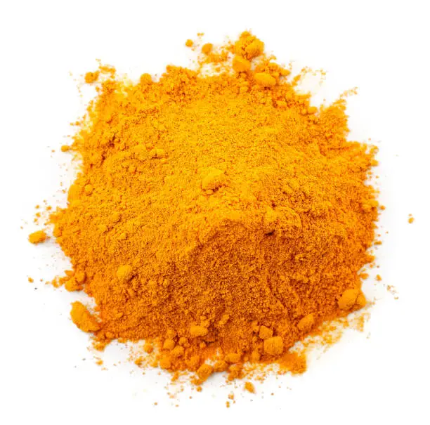 Heap of ground turmeric close up on white background, isolated. The view from top