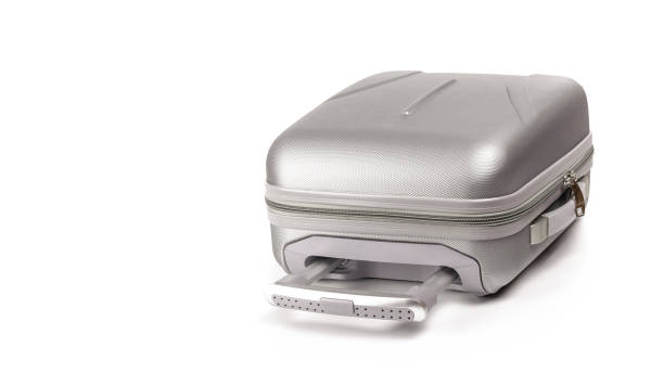 istock Suitcase white background. Silver plastic luggage or vacation baggage bag isolated. Copy space of summer vacation and business travel concept. 1291987407