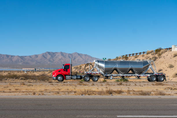 Oil Tank Semi Truck on A Three Way Highway Long Haul Semi Truck on a Highway pulling an oil tank trailer. oil tanker stock pictures, royalty-free photos & images