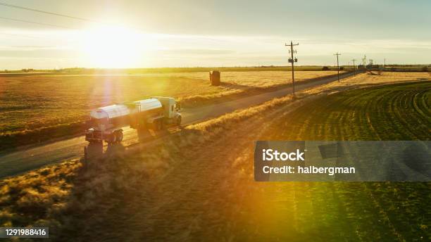 Aerial Shot Of Milk Tanker On Country Road With Dramatic Lens Flare Stock Photo - Download Image Now
