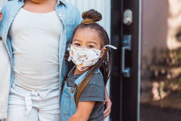 istock Adorable little girl wearing protective face mask 1291989227
