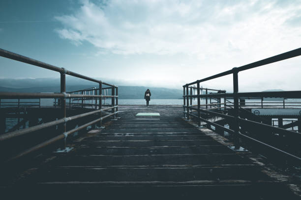 istock Woman standing on a pier 1291990914