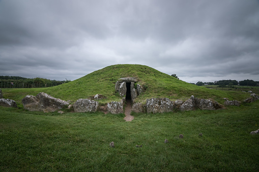 Bryn Celli Ddu, prehistoric druids tomb in Anglesey, North Wales, near Llanddaniel Fab. Green scenic in a cloudy day.