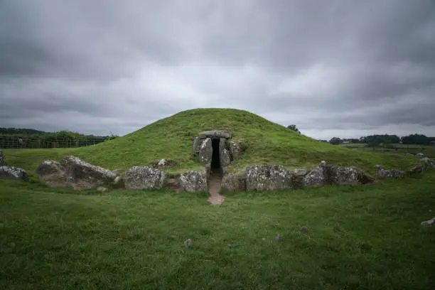 Bryn Celli Ddu, prehistoric druids tomb in Anglesey, North Wales, near Llanddaniel Fab. Green scenic in a cloudy day.