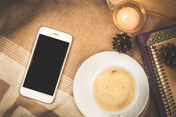 Home composition on plaid, cozy comfort with a cup of hot coffee and a smartphone, copy space