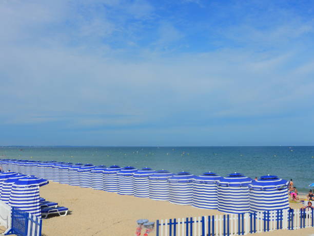 Beach cabanas line the beach in Cabourg, France