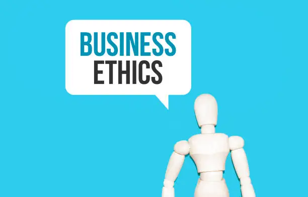 Photo of The wooden man and white cloud with text BUSINESS ETHICS. The content of the lettering has implications for business concept and marketing.