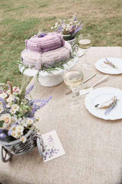istock boho style wedding cake on a table covered with a linen tablecloth, with plates, glasses, knife fork and a bouquet of flowers 1291997189