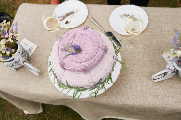 istock boho style wedding cake on a table covered with a linen tablecloth, with plates, glasses, knife fork and a bouquet of flowers 1291997215