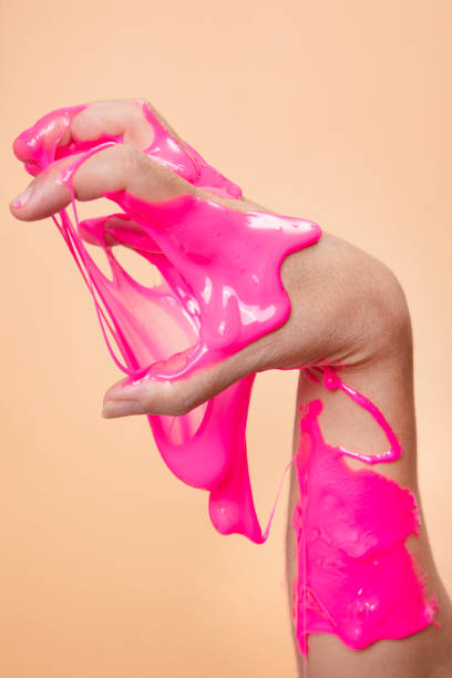 istock Hand holding something with Neon pink slime toy on orange pop art backgound. 1291999113