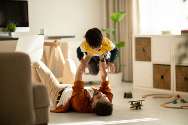 istock Joyful young man father lifting excited happy little son. 1292002941